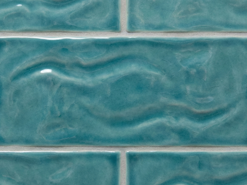 Close-up detail of glossy, turquoise wavy ceramic tiles perfect for a Solana Beach coastal home design.