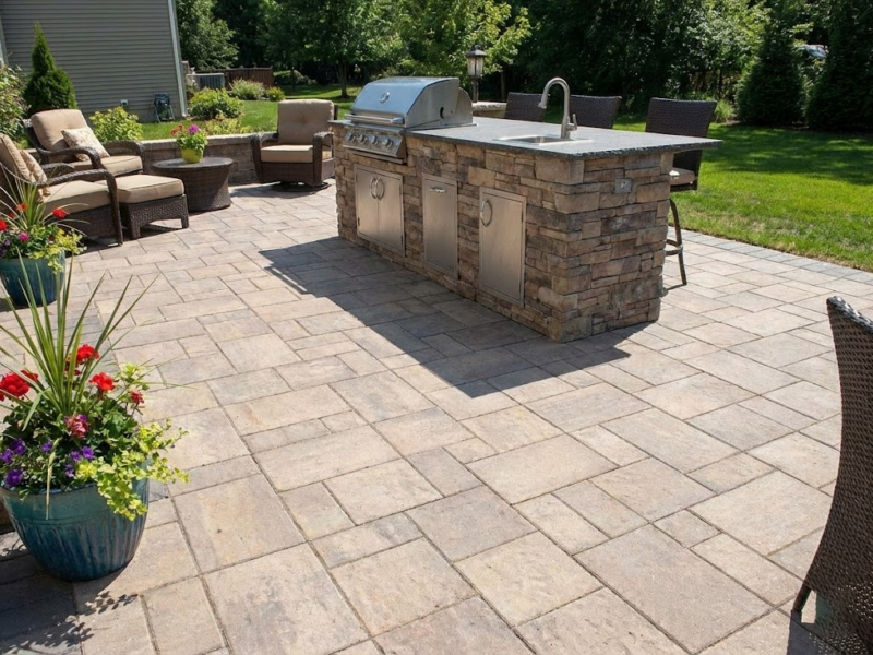 Outdoor Kitchen Patio: A beautiful Charmet Tile paver patio featuring a custom-built outdoor kitchen island with stacked stone veneer.