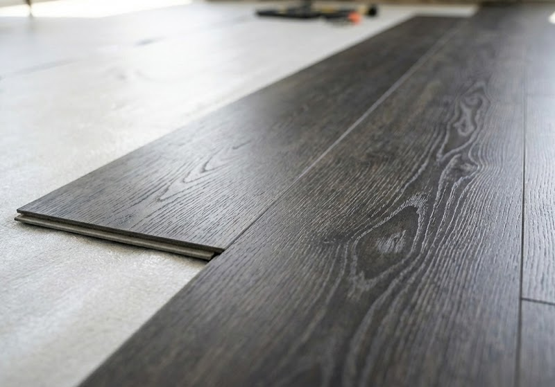 Close-up detail of dark oak luxury vinyl plank (LVP) flooring showing realistic wood grain texture and seamless interlocking installation.