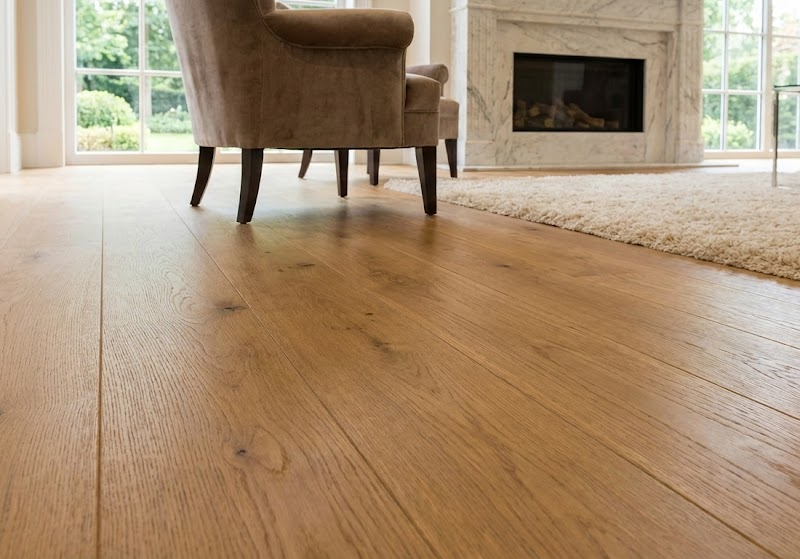 Close-up detail of wide-plank European oak hardwood flooring in a luxury living room, highlighting the natural grain texture and seamless installation.